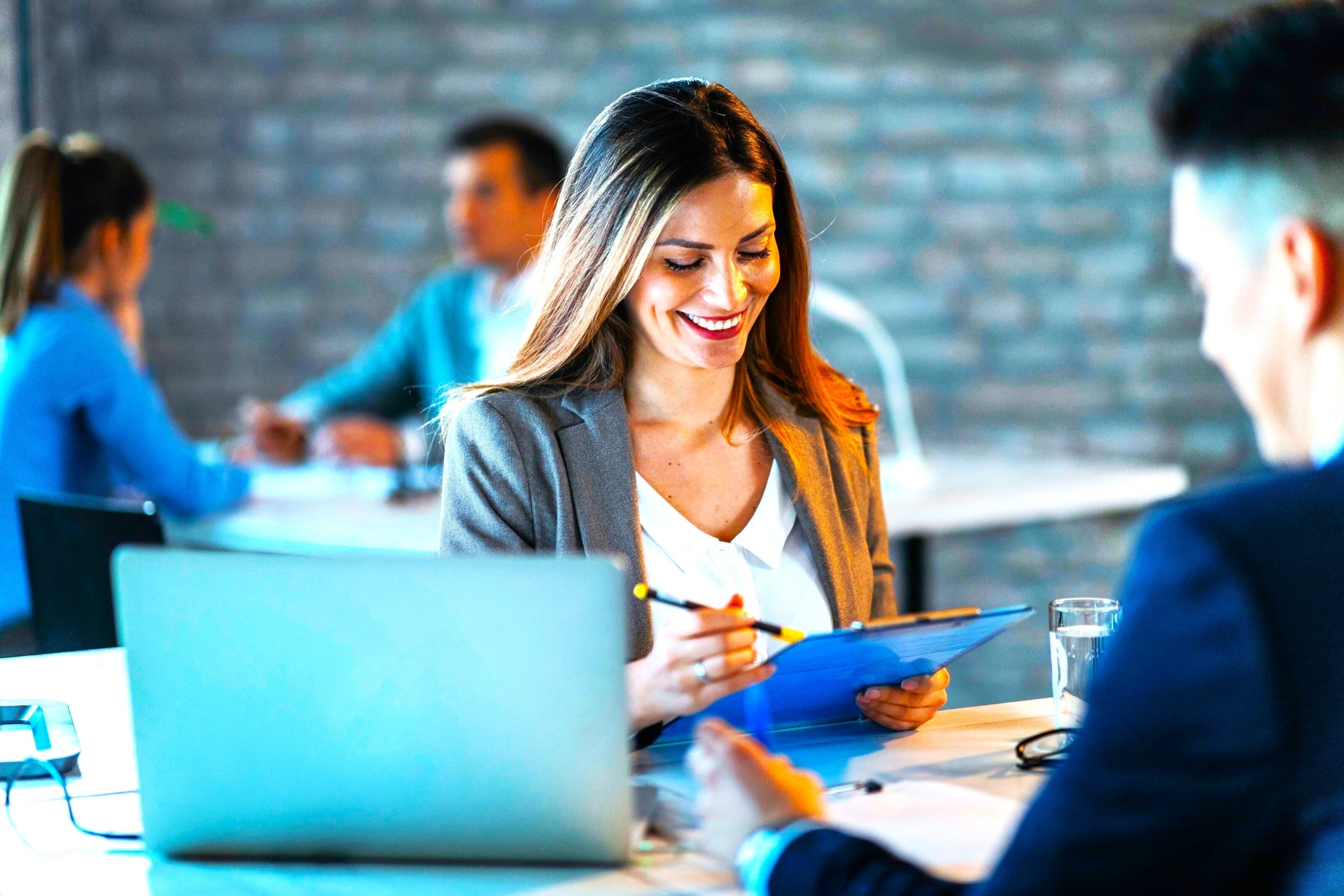 young-happy-businesswoman-reading-reports-while-going-through-paperwork-working-with-colleague-office